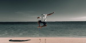 Man jumping on beach clicking his heels